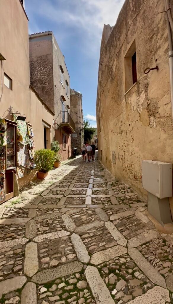 Cobblestone street lined with shops in Erice, Sicily.