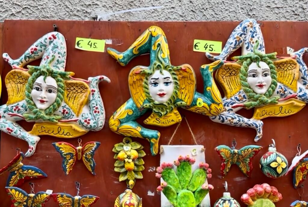 Colorful hand-painted Sicilian ceramic Trinacria ornaments displayed in a shop in Erice, Sicily.